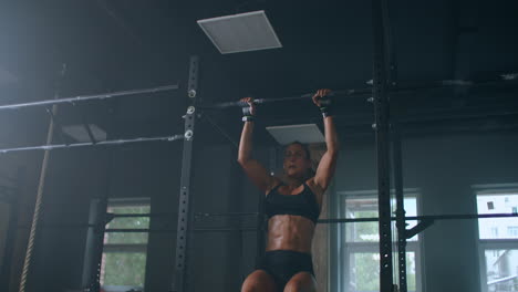 Female-Athlete-Swinging-On-Chin-Up-Bar.-Strong-women-Doing-Chin-ups-On-Gymnastic-Bars-In-Gym.-Professional-Athlete-Does-Chin-up-Power-Strength-and-Cross-Fitness-Exercises-and-Everyday-Workout-Routine.